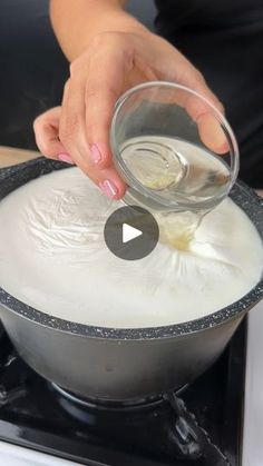 a person is mixing something in a pot on the stove with an electric burner