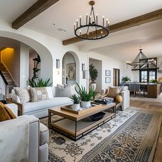 a living room filled with furniture and a chandelier hanging over the top of it