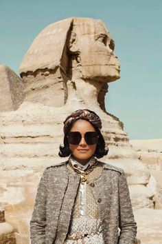 a woman wearing sunglasses standing in front of the sphinx at giza pyramids, egypt