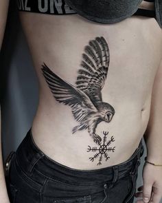 a woman's stomach with an eagle tattoo on it