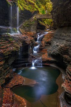 a waterfall in the middle of a canyon with water running down it's sides