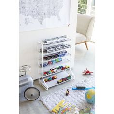 a white book shelf filled with lots of books on top of a carpeted floor