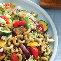 a pasta salad with zucchini, tomatoes, cucumbers and other vegetables