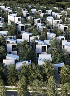 an aerial view of many white buildings surrounded by trees