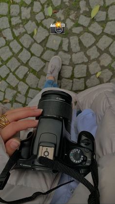 a person holding a camera in their hand and taking a picture with the lens up