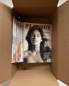 a cardboard box filled with magazines on top of each other