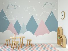 a child's room with mountains and clouds painted on the wall, including two stools