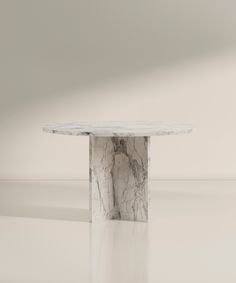 a white marble table sitting in the middle of a room with no one around it