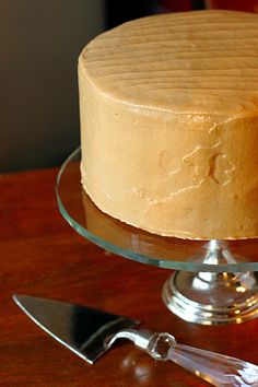 a cake sitting on top of a wooden table next to a knife