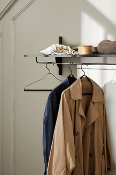 a coat rack with two coats hanging on it