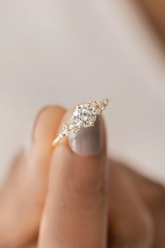 a woman's hand with a diamond ring on her finger, showing the side view