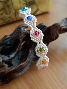 a close up of a piece of jewelry on a wooden table next to a tree branch