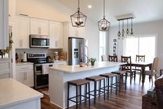 an open concept kitchen and living room with wood floors