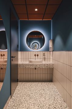 a public restroom with blue walls and white tiles on the floor is pictured in this image