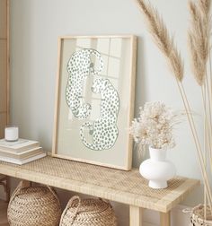 a wooden table topped with baskets and vases filled with flowers next to a framed letter