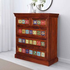 a wooden dresser with colorful tiles on the drawers