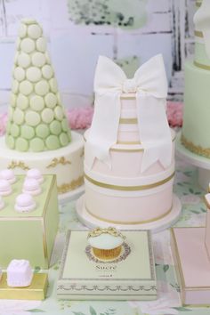 a table topped with lots of cakes and cupcakes