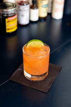 an orange drink sitting on top of a black table