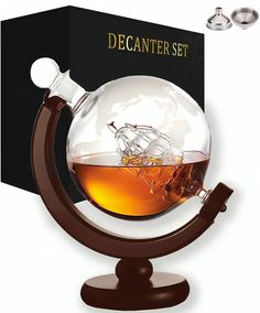 the decanter set includes a glass globe with a ship in it