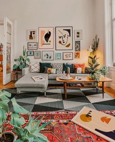 a living room filled with lots of furniture and pictures on the wall above it's windows