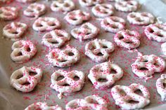 pink and white sprinkled donuts are on a baking sheet, ready to be baked