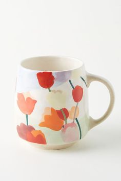 a coffee cup with flowers painted on the outside and inside, sitting on a white surface