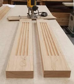 two pieces of wood sitting on top of a workbench with a driller