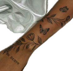 a woman's arm with butterflies on it and the words be brave written in black ink