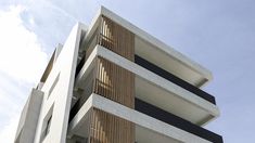 a tall white building with balconies on the sides