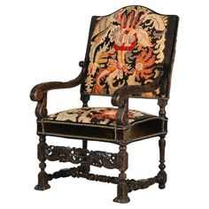 an ornately decorated wooden chair with embroidered upholstered back and armrests