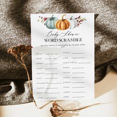 a pumpkin themed word scramble is on top of a piece of paper with dried flowers