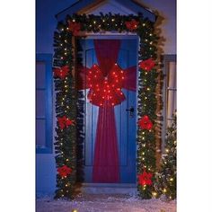 a lighted christmas door decoration with red bows and poinsettis in front of it