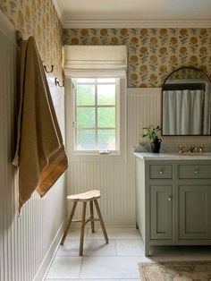 a bathroom with a stool, sink and mirror