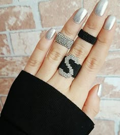 a woman's hand with three rings on it and one ring has the letter z