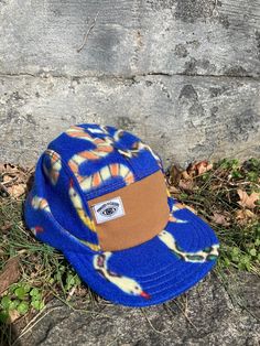 "This 5-panel hat is made from polar fleece with a super fun all-over snake print on a royal blue background. A combination of our traditional 5-panel camp hat style blended with the warmth of our Backcountry Hat's fold-over earflap panel. The front panel is a caramel-colored canvas with a woven Ministry of Culture logo in the upper corner. Fuzzy fleece ear flaps keep you warm when out and about during the winter months and can be folded up when not in use. The hat has an adjustable nylon pull t Retro Blue 5-panel Hat, Adjustable 5-panel Canvas Snapback Hat, Sporty 5-panel Snapback Hat For Camping, Blue 5-panel Snapback Hat For Outdoor, Adjustable 5-panel Snapback Hat For Skateboarding, Five Panel Hat, Canvas Hat, Royal Blue Background, Fleece Hats