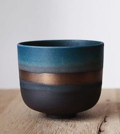 a blue and brown bowl sitting on top of a wooden table