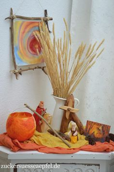 there is a vase with some branches in it and an orange pumpkin on the table