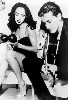 a man and woman sitting next to each other on a couch with guitars in their hands