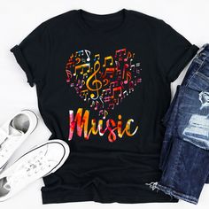 a black t - shirt with the word music written in colorful letters on it next to ripped jeans and white sneakers