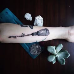 a person's arm with a tattoo on it and some white flowers next to it