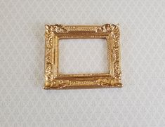 an ornate gold frame on a white wall