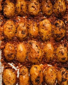 cooked meatballs on a baking sheet covered in sauce