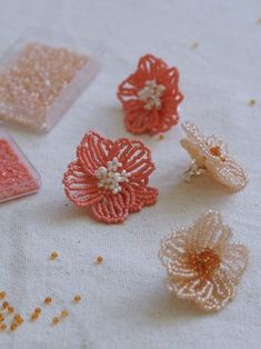 four different types of beaded flowers sitting on a table top next to each other