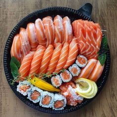 an assortment of sushi in a black bowl