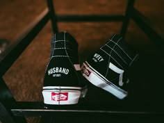 a pair of black and white shoes sitting on top of a bench