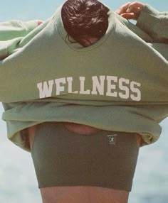 a woman with her back to the camera, wearing a sweatshirt that says'w f lnesss '