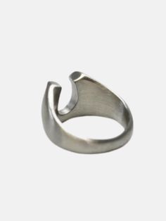 a silver ring with an open design on the front and back side, sitting against a white background