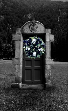 a black and white photo of a wreath with skulls on it in front of a door