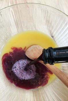 a glass bowl filled with liquid and a wooden spoon