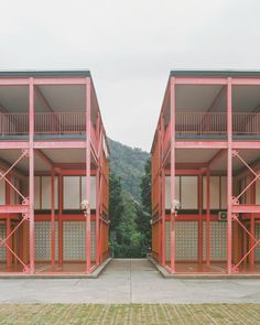 two red buildings with balconies on each floor